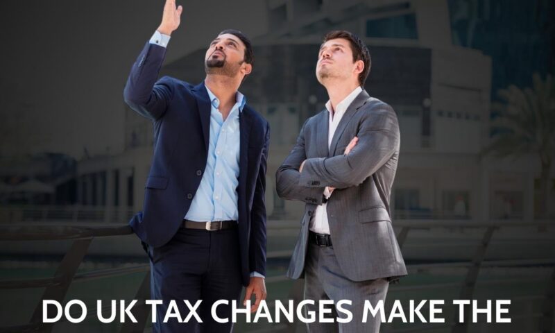 Two businessmen looking up at the sky outside a modern Dubai building, captioned why Dubai, do UK tax changes make the UAE even more appealing